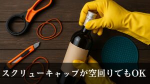 ワインボトルのスクリューキャップを黄色いゴム手袋で開けようとしている場面。周囲にはストラップレンチ、輪ゴム、カッター、シリコンマットが並べられている